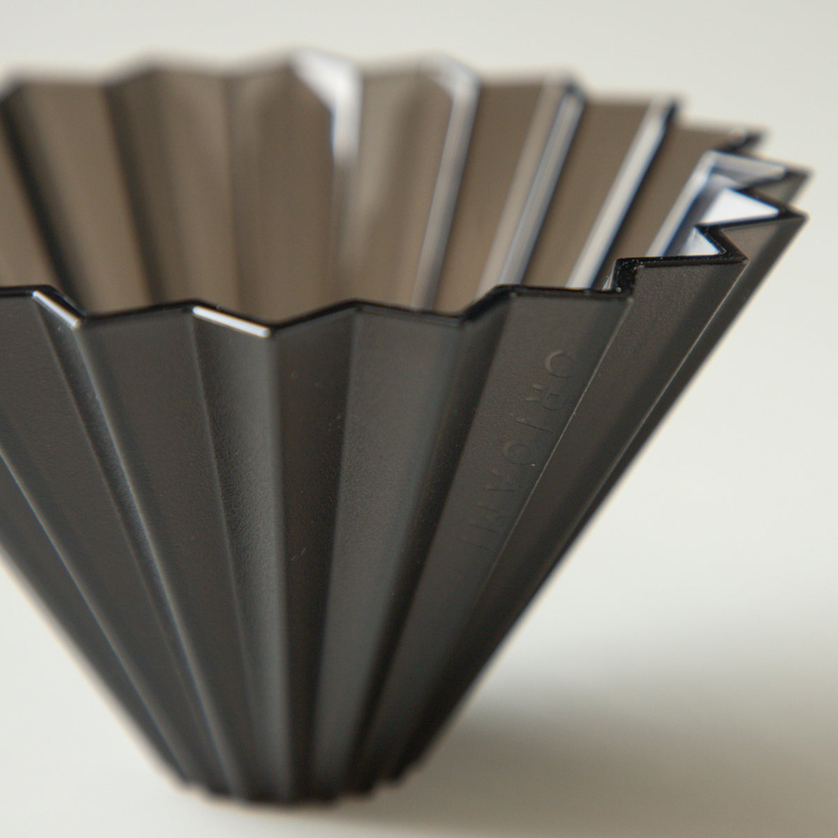 Black Comandante Origami Air S plastic coffee grinder with stainless steel burrs and compact design.